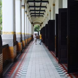 Rear view of people walking in corridor of building