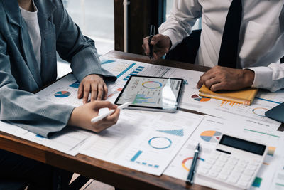 Midsection of business colleagues working at desk in office