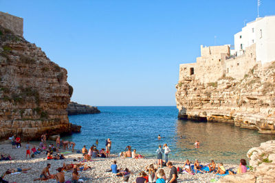 People on beach against clear sky