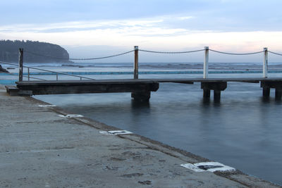 Suspension bridge over sea against sky