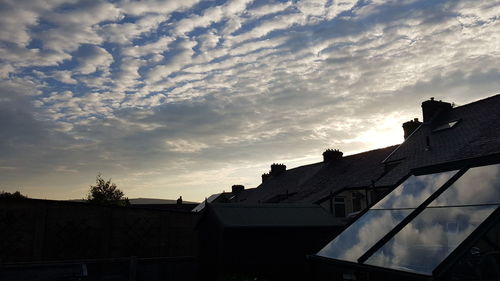 Low angle view of silhouette buildings against sky