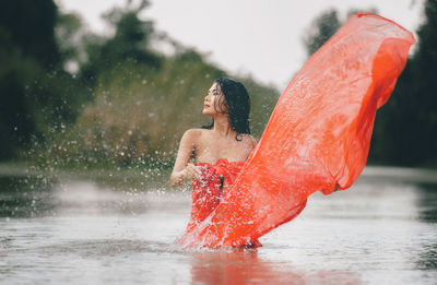 Midsection of woman splashing water in rain