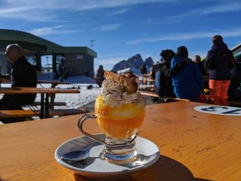 Close-up of drink on table at cafe against sky