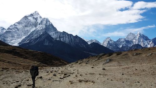 Rear view of person on snowcapped mountains against sky