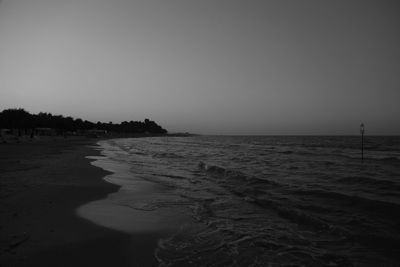 Scenic view of beach against clear sky during sunset