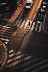 High angle view of silhouette man crossing street in city