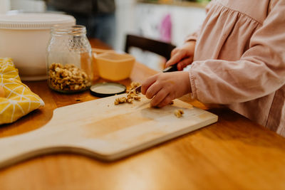 Child cutting walnuts for baking