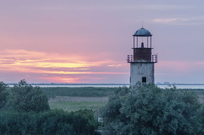 Tower on field against sky during sunset