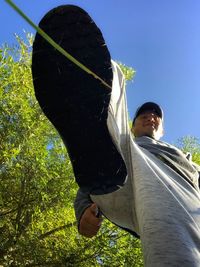 Low angle view of woman standing against sky