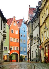 Houses by street against sky in city