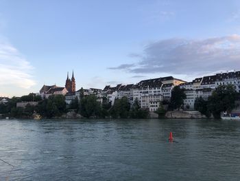 River amidst buildings in city against sky