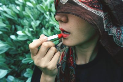 Close-up portrait of a woman holding cigarette