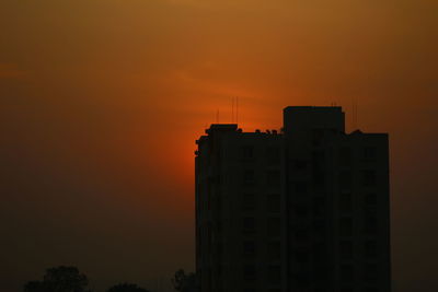 Silhouette buildings against sky during sunset