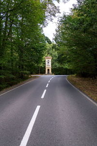 Road sign by trees in city