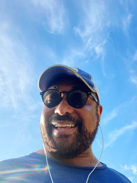 Portrait of young man wearing sunglasses against sky