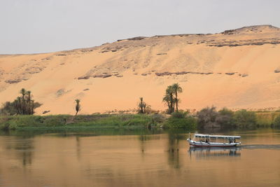 Scenic view of boat on the nile against sahara desert