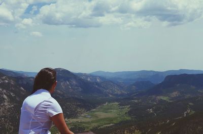 Rear view of woman looking at mountain against sky