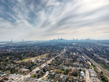 High angle view of city buildings against cloudy sky