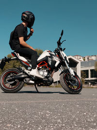 Man riding motorcycle on road against sky