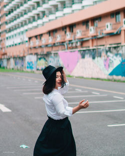 Full length of woman standing on road in city