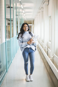 Full length portrait of woman standing in building