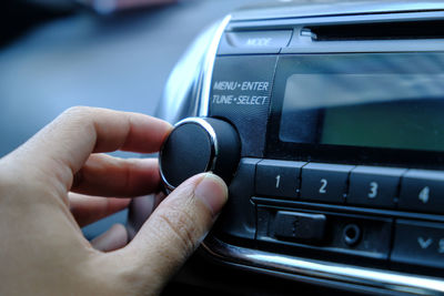 Cropped hand using volume knob in car