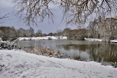 Scenic view of lake against sky during winter