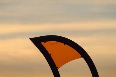 Low angle view of silhouette metal against sky during sunset