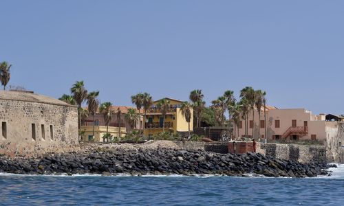 Houses by sea against clear sky