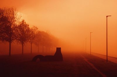 Silhouette trees against orange sky during sunset