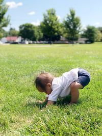 Baby girl crawling on grassy land