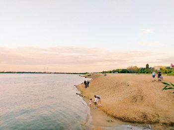 People walking on beach against sky