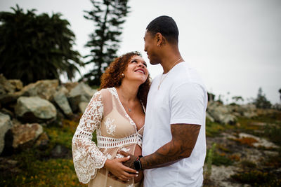 Young couple standing against sky