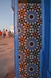 Close-up of patterned wall by building against sky