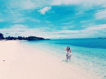 People enjoying at beach against sky