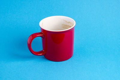 Close-up of coffee cup on table against blue background