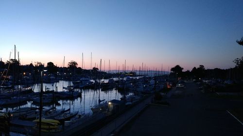 Boats moored at harbor against sky during sunset