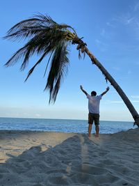 Rear view of woman standing on beach