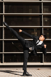 Full length of man standing against glass wall