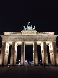 Statue in city at night