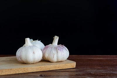 Close-up of garlic on table against black background