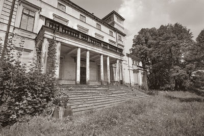 Exterior of old building by tree against sky