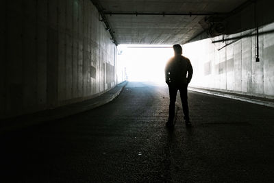 Rear view of silhouette man in tunnel