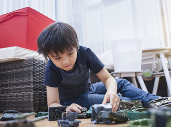 Rear view of boy sitting on table