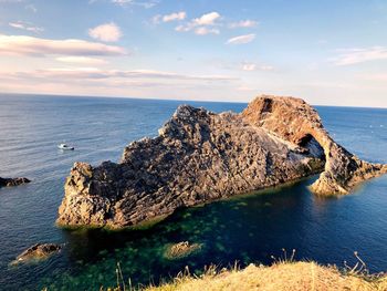 Scenic view of rocks in sea against sky