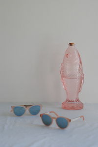 Close-up of sunglasses on table against wall