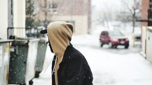 Rear view of man in snow on city street during winter