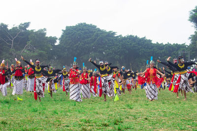 Group of people on field against trees