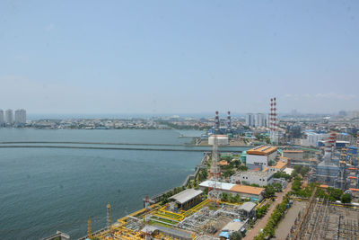 High angle view of buildings by sea against clear sky