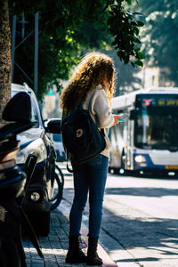 Rear view of woman standing on street in city